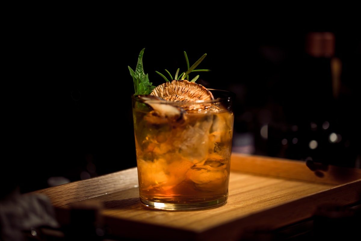Cocktail ambrato con rosmarino e scorza essiccata