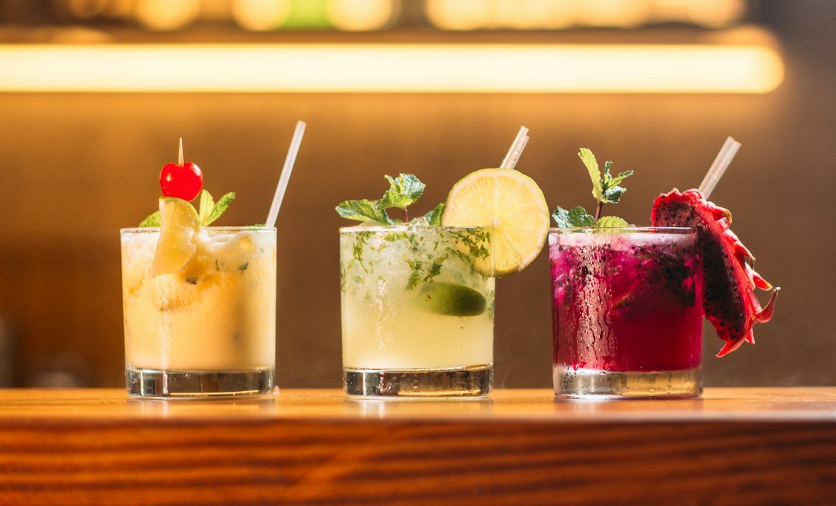 Tre cocktail colorati con lime, menta e frutto del drago
